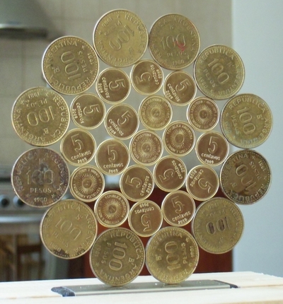 image: Standing hexagonal   rose / mandala of coins of  Argentina  (centre, r1, r2: 5 cvss 2009, r3 : 100 pesos 1982)           